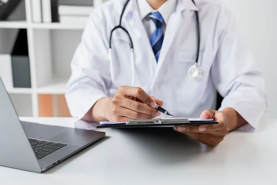 doctor-holding-the-patient-report-file-to-assess-symptoms-on-the-desk-2